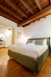 a large bed in a room with wooden ceilings at Pantheon Luxury House - ZEN 28 in Rome