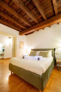 a bedroom with a large white bed with wooden ceilings at Pantheon Luxury House - ZEN 28 in Rome