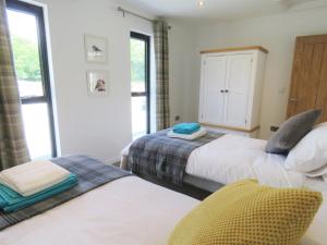 a bedroom with two beds and a window at Ochre Cottage in Bradworthy