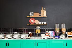 una cocina con armarios verdes y una pared negra en The Rockley by Ocean Hotels - Breakfast Included, en Bridgetown