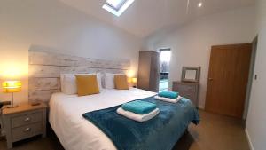 een slaapkamer met een groot bed en handdoeken bij Umber Cottage in Bradworthy