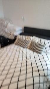 ein Bett mit einer schwarzen und weißen Bettdecke und 2 Kissen in der Unterkunft Bike Park Cottage Sleeps 5 with Pet in Merthyr Tydfil