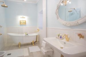 een badkamer met een bad, een wastafel en een spiegel bij VILLA TOJI luxury private - Adults only in Bracciano