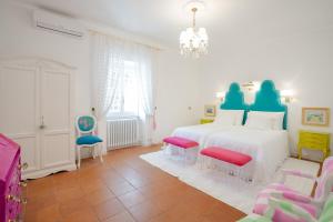 een slaapkamer met een wit bed en 2 stoelen bij VILLA TOJI luxury private - Adults only in Bracciano