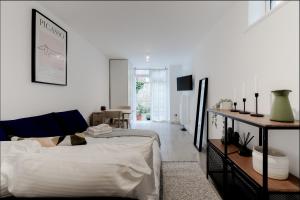 een slaapkamer met een bed en een woonkamer bij Charming Hampstead Garden Studio in Londen