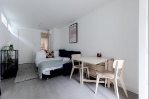 een kamer met een bed, een tafel en een bank bij Charming Hampstead Garden Studio in Londen