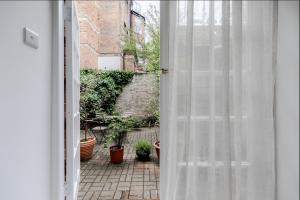 een open deur naar een patio met potplanten bij Charming Hampstead Garden Studio in Londen