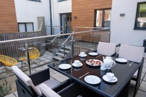 a table with a bowl of food on a balcony at 2 Rockham - Luxury Apartment at Byron Woolacombe, only 4 minute walk to Woolacombe Beach! in Woolacombe