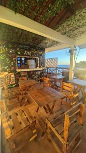 a restaurant with wooden tables and chairs and a wall at Hostel Recanto da Sereia in Salvador