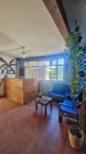 sala de estar con sofá azul y mesa en Hostel Recanto da Sereia en Salvador