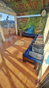 a room with a mural on the wall and a table with books at Hostel Recanto da Sereia in Salvador