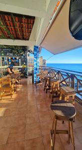 um restaurante com mesas e cadeiras de madeira e o oceano em Hostel Recanto da Sereia em Salvador