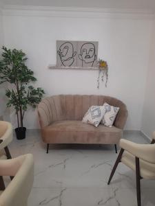a living room with a brown couch and some plants at Apartamento centro de la ciudad 2 in San Pedro de Macorís