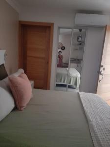 una camera da letto con un letto con un cuscino rosa e uno specchio di Apartamento centro de la ciudad 2 a San Pedro de Macorís