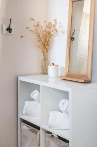 estante blanco con toallas y espejo en La Parenthèse - Annecy- Grande Terrasse - Chambre - Garage, en Annecy