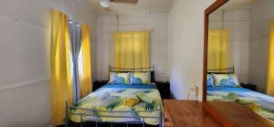 a small bedroom with two beds and a mirror at Meyenburg Unit 1 in Mount Morgan