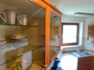 einem Glasschrank mit Schalen und Vasen in einer Küche in der Unterkunft Ferienwohnung Seeriwa in Stockach