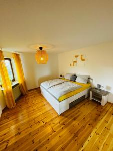 ein Schlafzimmer mit einem großen Bett und Holzboden in der Unterkunft Ferienwohnung Seeriwa in Stockach