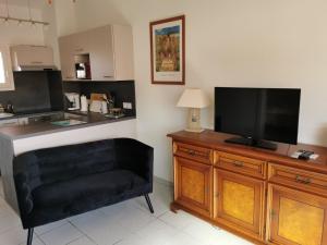 a living room with a television on a wooden dresser at Rue de Corfou Les Grenadines in Sainte-Marie-la-Mer