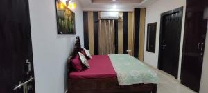 a small bedroom with a bed with pink sheets at 360 degree mountain view penthouse in Rishīkesh