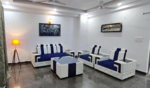 a room with blue and white chairs and a table at 360 degree mountain view penthouse in Rishīkesh
