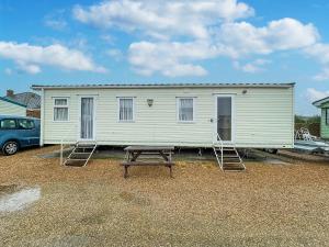 a white house with a picnic table in front of it at 6 Berth Dog Friendly Caravan In Hunstanton In Norfolk Ref 13014l in Hunstanton