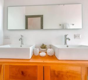 La salle de bains est pourvue de 2 lavabos et d'un miroir. dans l'établissement Modern Home with Panoramic Ocean View and Pool, à Ojochal