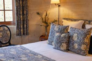 a bedroom with a bed with blue and white pillows at Ferme de la Ran&ccedil;onni&egrave;re - H&ocirc;tel & Restaurant in Cr&eacute;pon
