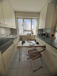 een keuken met witte kasten en een tafel. bij Wohnung Sonnenblume in Langenargen