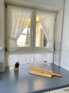 een aanrecht met een raam met witte gordijnen bij Wohnung Sonnenblume in Langenargen