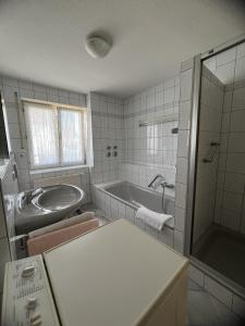 een witte badkamer met een bad en een wastafel bij Wohnung Sonnenblume in Langenargen