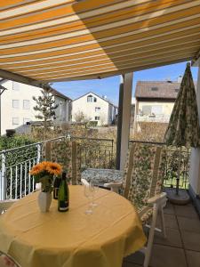 een tafel met 2 wijnglazen en bloemen op een balkon bij Wohnung Sonnenblume in Langenargen
