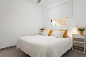 アルクーディアにあるApartamento Concha junto a playa, CLAVELLS 1 1ER Dの白いベッドルーム(白いベッド1台、窓付)