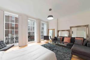 een woonkamer met een groot bed en een bank bij Exclusive Mayfair Apartment Suite in Londen
