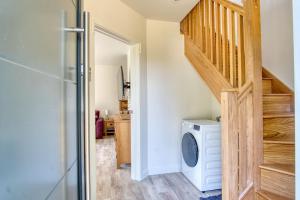 a laundry room with a washing machine and a staircase at Retreat by the Mill - for a relaxing getaway in Cottered