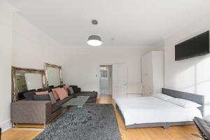 een woonkamer met een bank en een bed bij Exclusive Mayfair Apartment Suite in Londen