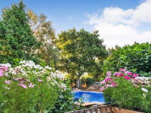 a garden with a swimming pool surrounded by flowers at Retreat by the Mill - for a relaxing getaway in Cottered
