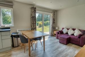 ein Wohnzimmer mit einem lila Sofa und einem Tisch in der Unterkunft Retreat by the Mill - for a relaxing getaway in Cottered