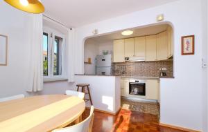 a kitchen and dining room with a table and a fireplace at 3 Bedroom Nice Apartment In Mali Losinj in Mali Lošinj