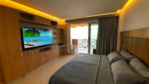 um quarto com uma cama e uma televisão de ecrã plano em Hermosa Siute frente al mar en Tolu-Sucre em San Silvestre