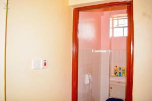 a bathroom with a shower and a mirror at The Bay House in Homa Bay