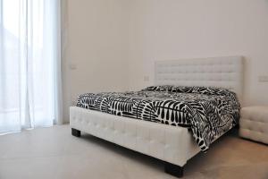 uma cama num quarto branco com um cobertor de zebra em Appartamento Medea em Cavernago
