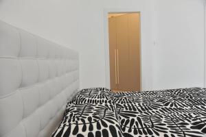 a bedroom with a black and white comforter on a bed at Appartamento Medea in Cavernago