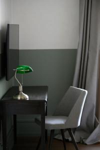 a desk with a green lamp and a chair at Grandiose Athens Apartment | 1 Bedroom Suite | Apartment Weisslogia | Athinaidos in Athens