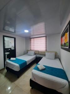 1 Schlafzimmer mit 2 Betten und einem Fenster in der Unterkunft Hotel Zafiro Boutique in Bogotá