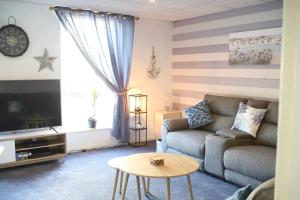 uma sala de estar com um sofá e uma mesa em Pass the Keys 2 bed town centre flat Llanelli · Modern and bright town centre flat in Llanelli em Llanelli