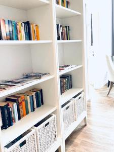 a white book shelf filled with books at Gästehaus Teerlings Hafen in Borkum