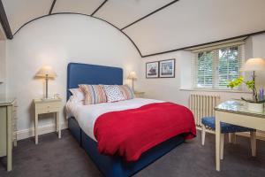 a bedroom with a bed with a red blanket on it at Cary Arms & Spa in Torquay