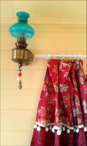 einem Kleiderbügel mit einem Vorhang und einem Licht an der Wand in der Unterkunft Roulotte "Grain de Folie" in Waben