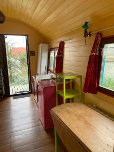 uma cozinha com uma mesa verde e um fogão em Roulotte "Grain de Folie" em Waben